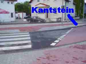 Porth 2006 &copy; Schlimmer noch - die neue Markierung auf der Kreuzungsinsel leitet den Radfahrer augenscheinlich auf den Kantstein. Was soll das?