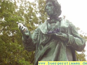 Porth , 2007 &copy; Angesichts des schlechten Wetters hat sich jemand erbarmt und dem ber&uuml;hmten G&ouml;ttinger Chemiker W&ouml;hler Energiedrink und Regenschirm dagelassen.